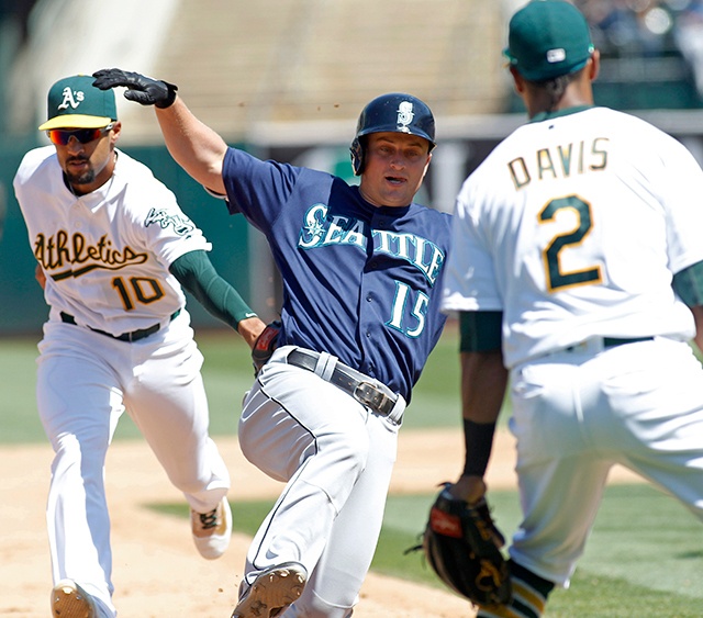 The Associated Press Seattle’s Kyle Seager (15) is tagged out near third base by Oakland Athletics’ Marcus Semien (10) during the sixth inning of the Mariners’ 8-4 win. Seager hit a three-run double and was caught off second base.