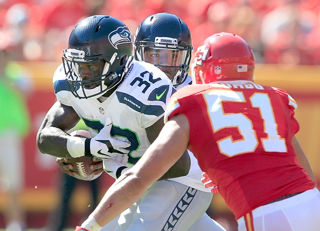 The Associated Press                                Seattle’s Christine Michael (32) runs between his quarterback Trevone Boykin, rear, and Kansas City Chiefs linebacker Frank Zombo during the Seahawks preseason victory.