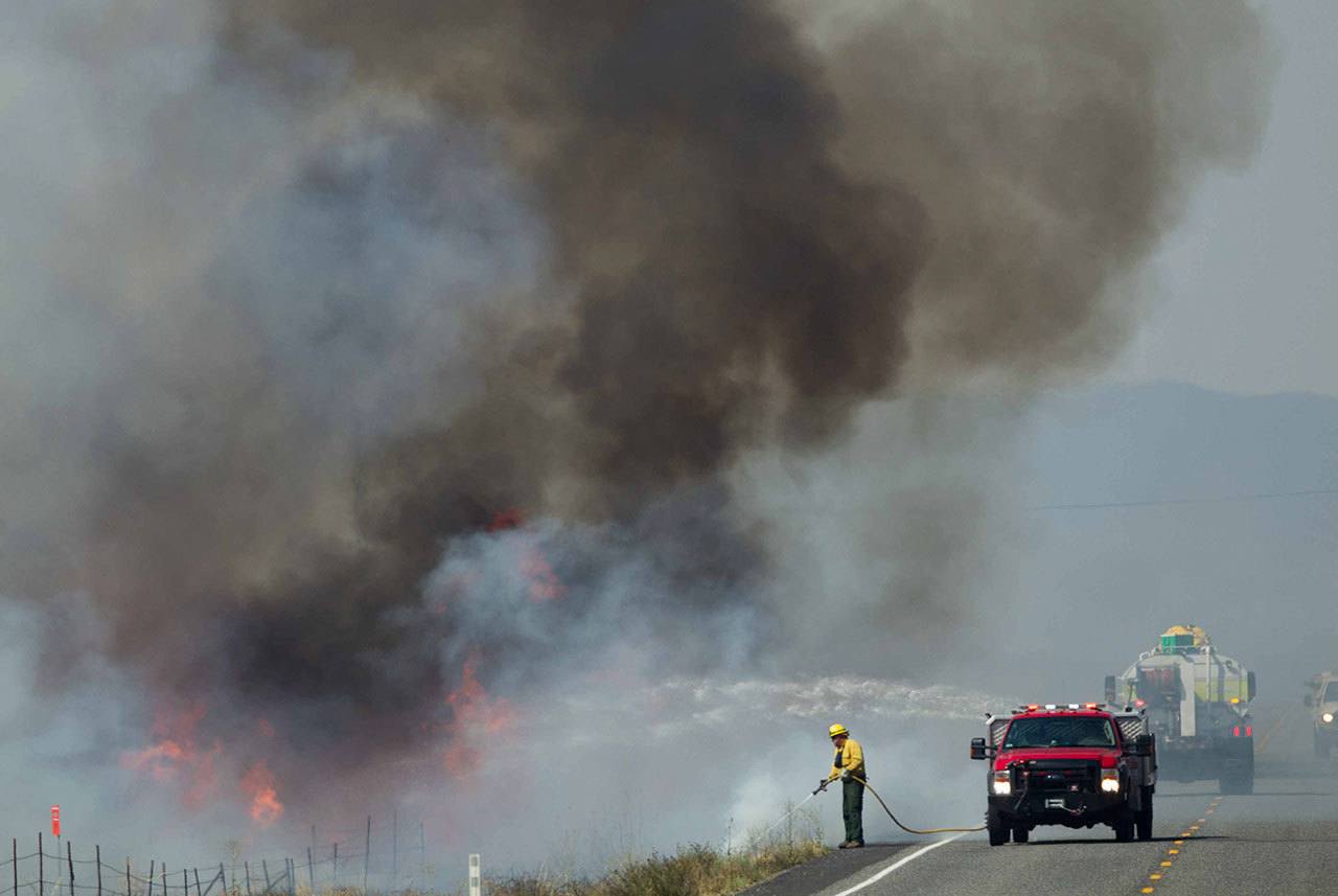 A wildfire burns between Moxee and Sunnyside on Sunday, July 31. The fire started on U.S. Army’s Yakima Training Center land near Moxee. The wildfire that burned toward the Hanford Nuclear Reservation scorched about 110 square miles as it spread from Grant and Yakima counties into Benton County. (Sofia Jaramillo/Yakima Herald-Republic via AP)