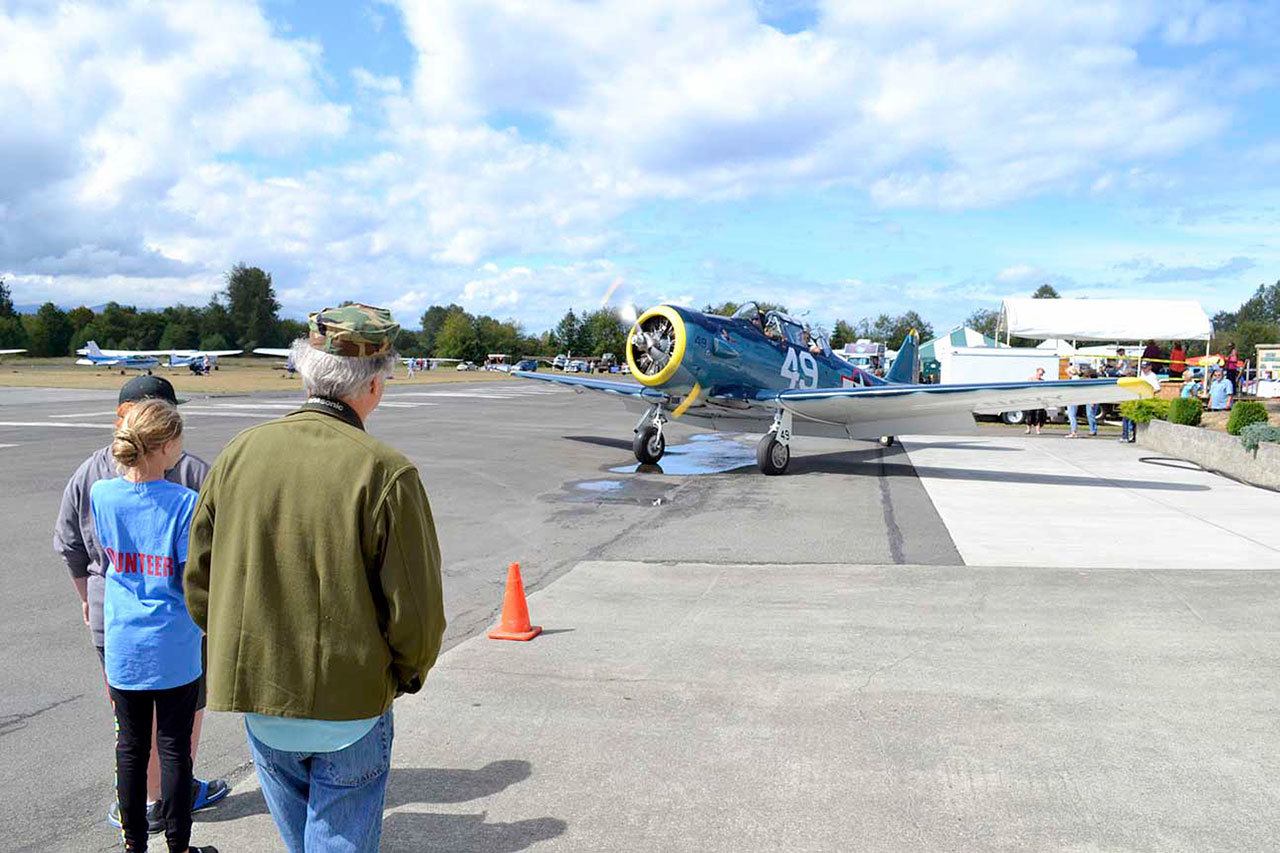 Visitors to the Olympic Peninsula Air Affaire look at the Capt. Johnny Johnson’s North American T-6 Texan single-engine advanced trainer aircraft as it arrives last year. Johnson hopes to return to the event Sunday. (Matthew Nash/Olympic Peninsula News Group)