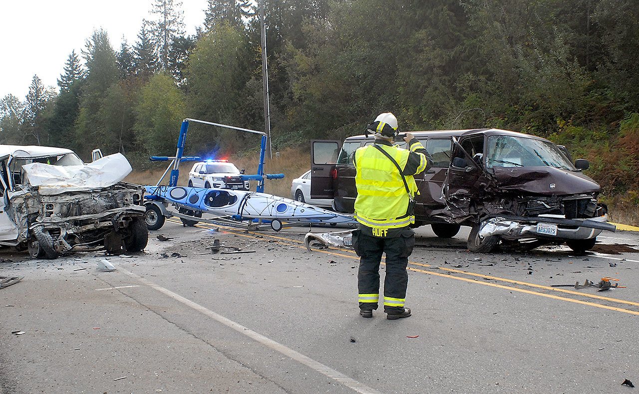 Clallam County Fire District No. 2 Assistant Chief Dan Huff takes photographs of a van involved in a three-vehicle collision on U.S. Highway 101 east of Laird Road near Port Angeles on Friday. (Keith Thorpe/Peninsula Daily News)