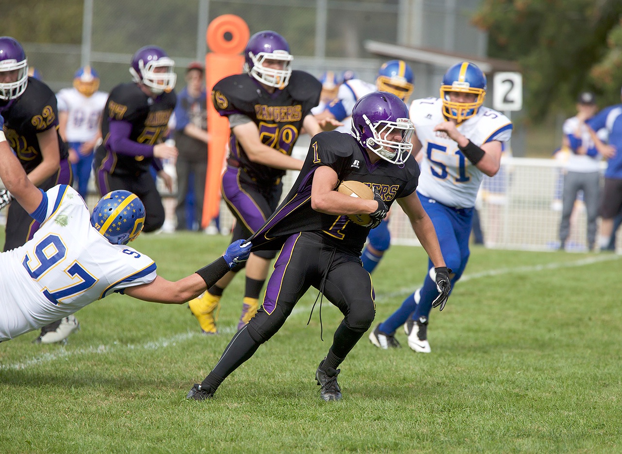 Steve Mullensky/for Peninsula Daily News Quilcene’s Ace Elkins, runs upfield for a first down despite the grasp on his jersey by Crescent’s McCabe Story during the Rangers’ 40-24 victory over the Loggers.