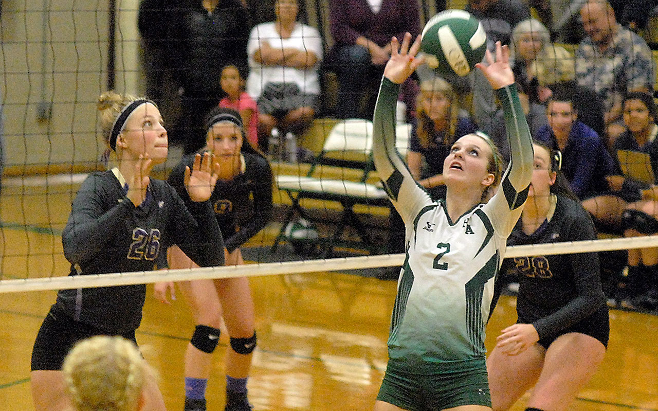Keith Thorpe/Peninsula Daily News                                Port Angeles’ Callie Hall, center, sets the ball as Sequim players, from left, Ella Christiansen, Maddie Potts and Tayler Breckenridge look on in the second game of their match at Port Angeles High School.