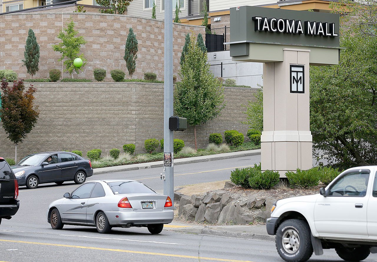 Cars pass by an entrance to the Tacoma Mall on Wednesday in Tacoma. A Washington state teenager who was riding her bicycle through the mall parking lot when an off-duty officer working as a security guard threw her to the ground and shocked her with a stun gun is suing the Tacoma Police Department. (Ted S. Warren/The Associated Press)