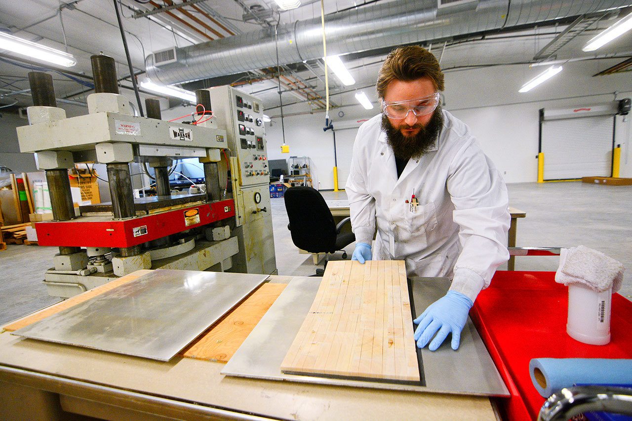 Joel Lippold, product developer with the Composite Recycling Technology Center, makes a construction composite panel Monday as part of CRTC’s research and development effort. (Jesse Major/Peninsula Daily News)