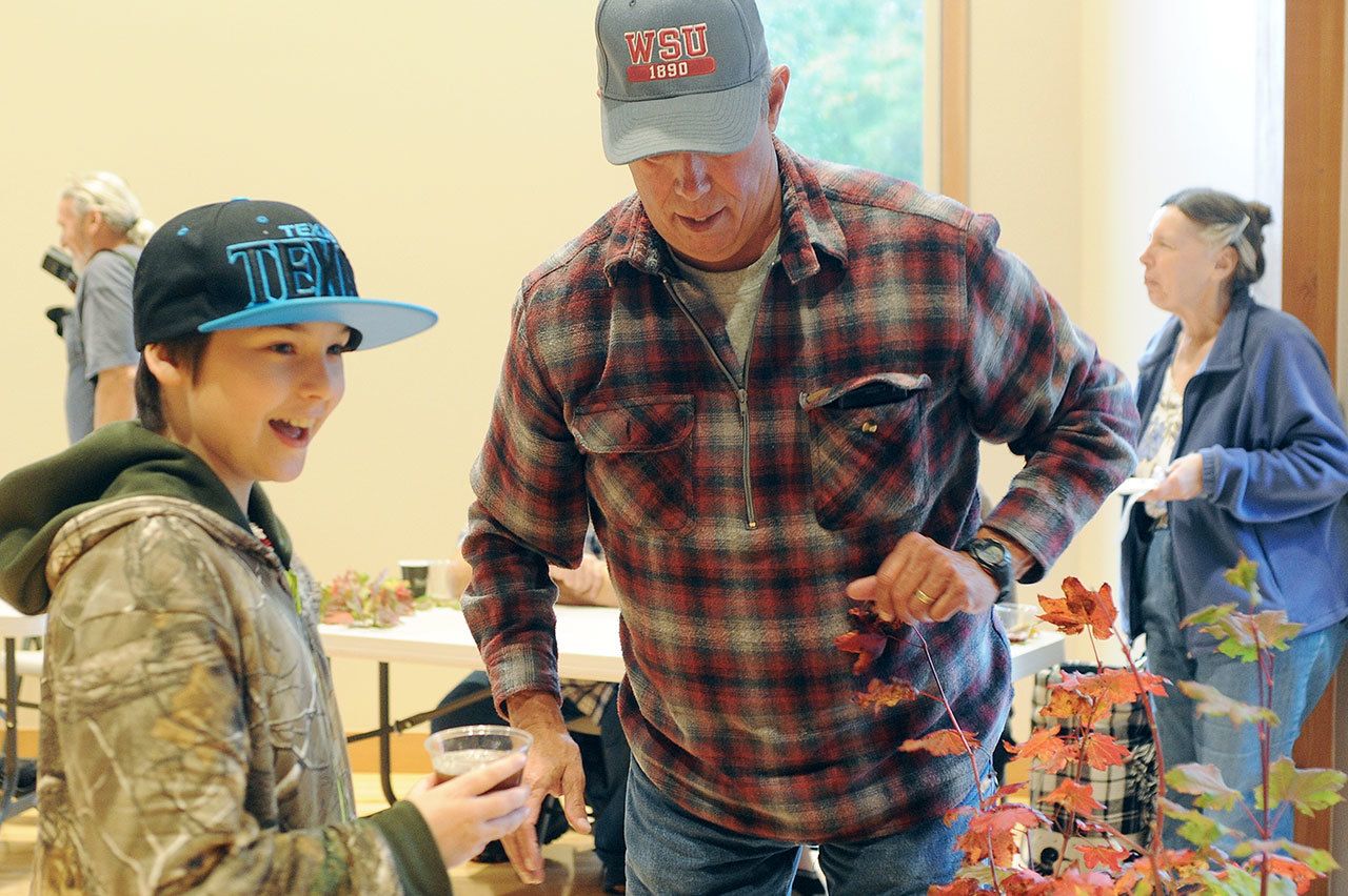 Lonnie Archibald/for Peninsula Daily News                                Sean Thornhill drinks Gordon Gibbs’, right, Root Beer during last years Fish and Brew held at the RAC.