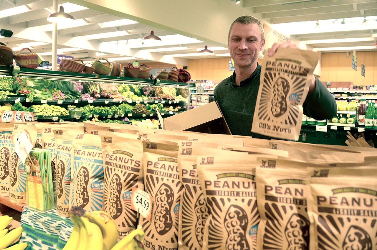Port Townsend Co-Op employee Adam Carter stocks shelves at the store. (Cydney McFarland/Peninsula Daily News)