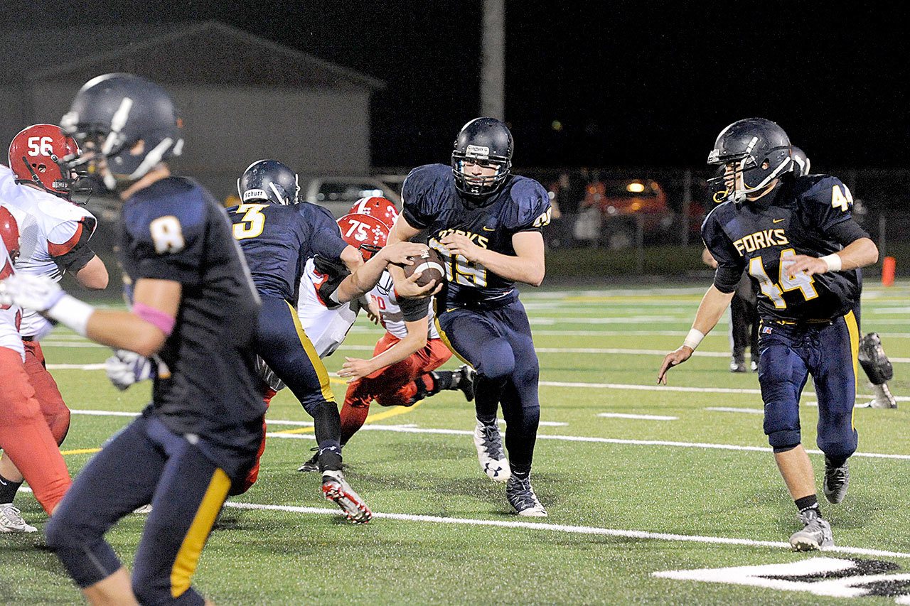 Lonnie Archibald/for Peninsula Daily News Forks’ Jack Dahlgren runs for a good gain during the Spartans’ 22-20 homecoming victory over Tenino. Blocking for Forks are Gavin Palmer (8), Brett Moody (3), and Garrison Schumack (44).