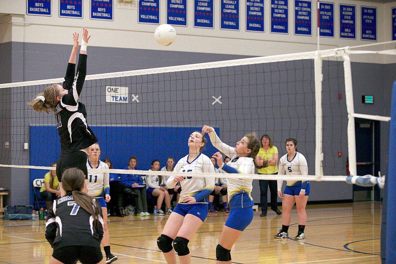 Steve Mullensky/for Peninsula Daily News                                Chimacum’s Taylor Cartum (7) watches as teammate Kaitlyn Ejde (11) jumps up to block a shot by Crescent’s Hannah Lee as teammates Alyssa Hutto (11) and Ashara Dodson (15) back up the play, during volleyball action on Monday in Chimacum.
