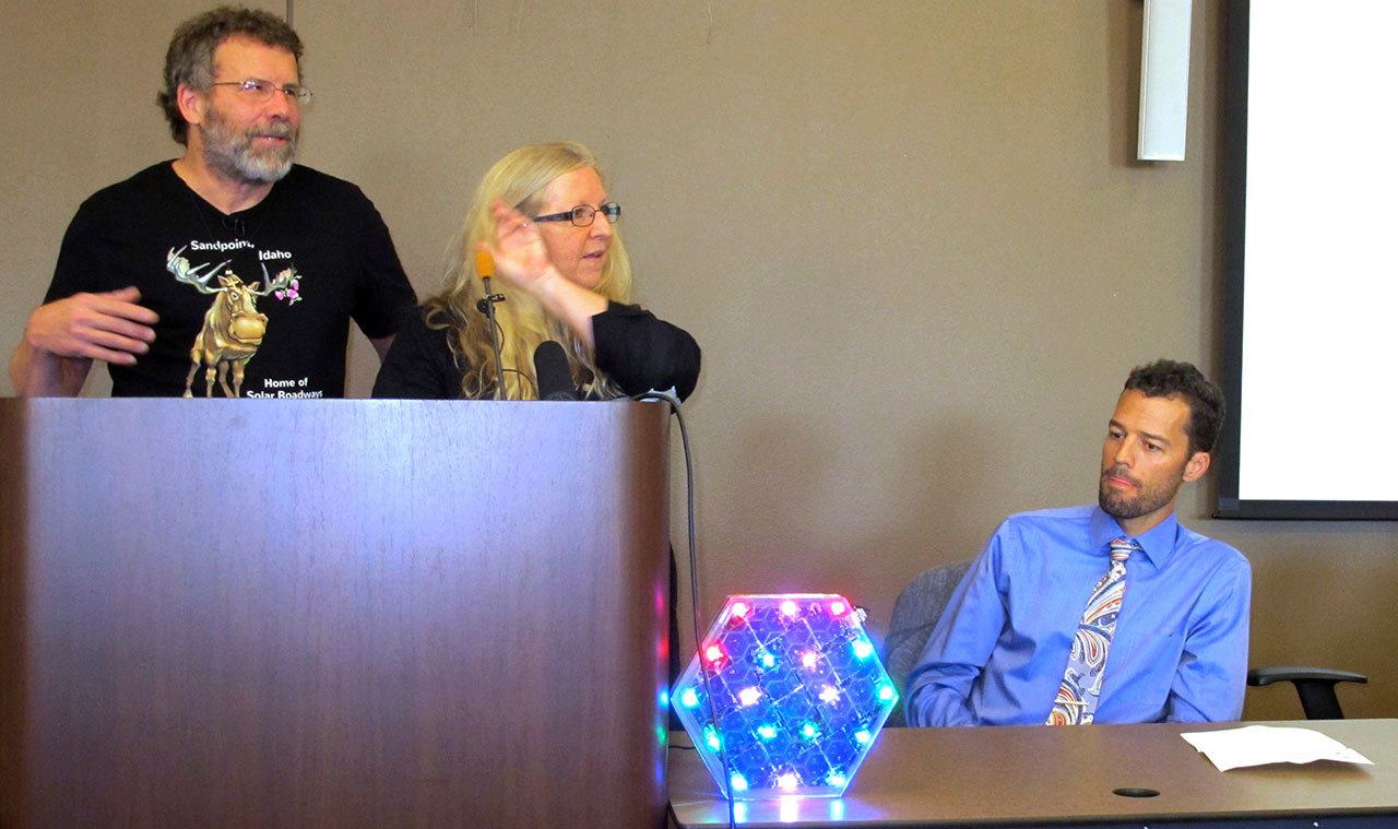 Solar Roadways founders Scott Brusaw, left, and Julie Brusaw display a 1/3-sized replica of one of their solar pavement panels at a news conference Sept. 30 in Sandpoint, Idaho, as Sandpoint mayor Shelby Rognstad looks on at right. (AP Photo/Nicholas K. Geranios)