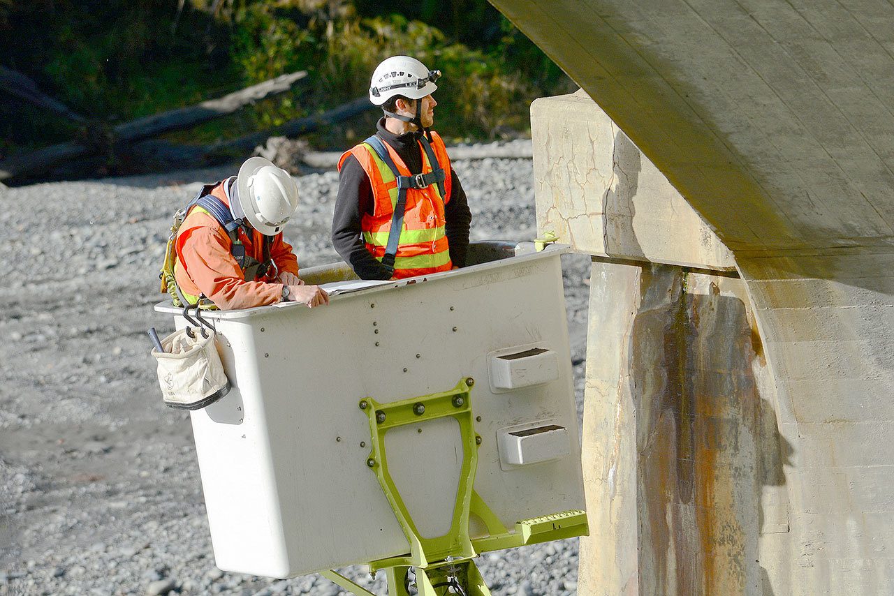 State Department of Transportation crews work Tuesday to inspect cracks in the Elwha River bridge on U.S. Highway 101 west of Port Angeles and to install crack monitors. (Jesse Major/Peninsula Daily News)
