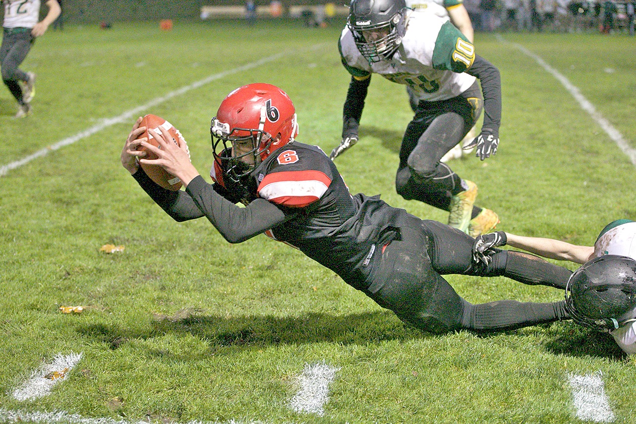 Steve Mullensky/for Peninsula Daily News Port Townsend’s Gerry Coker, dives forward after being tackled during a game with Vashon last month at Memorial Field. The Redhawks host Charles Wright tonight at 7 p.m.