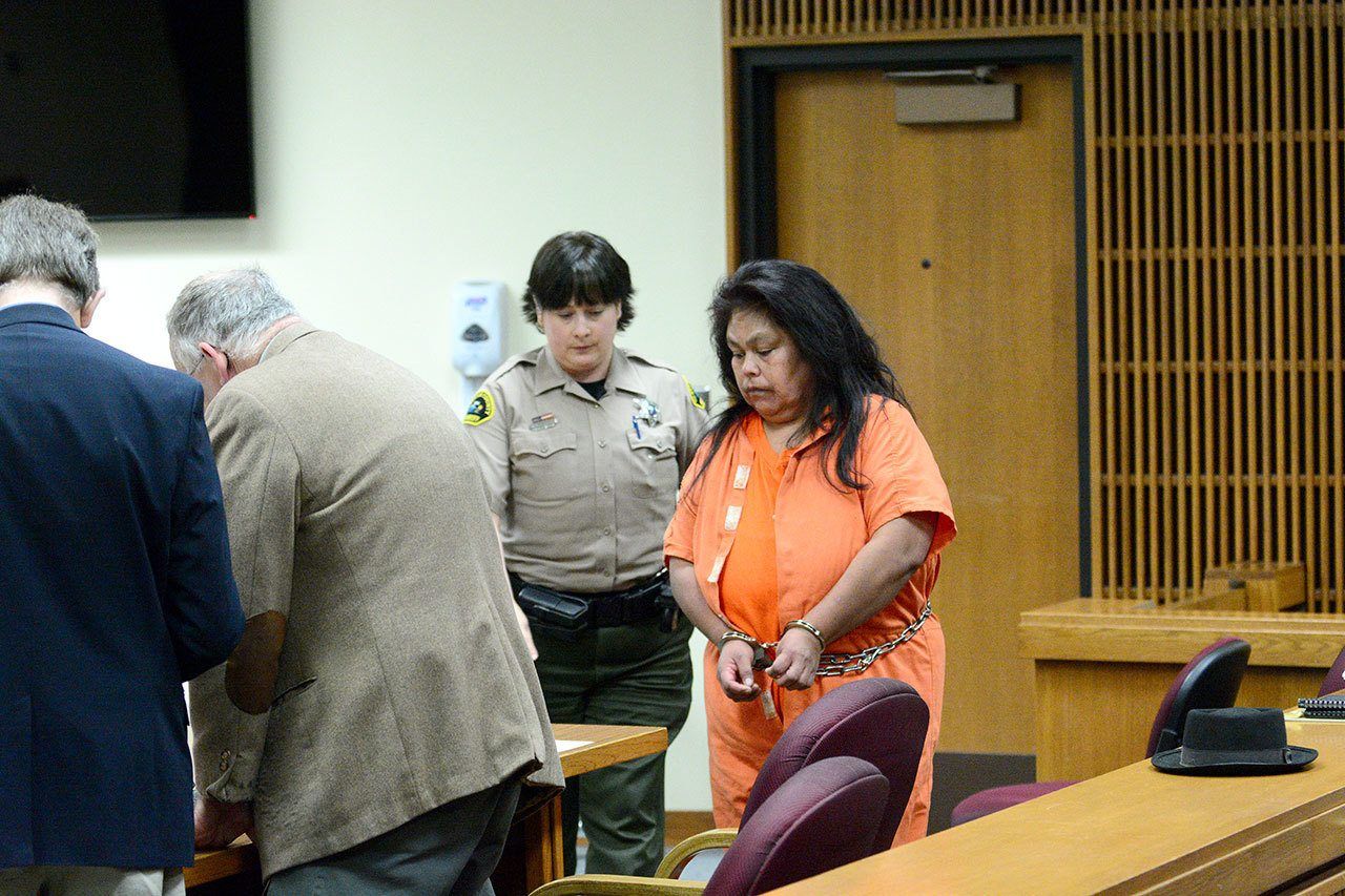 A Clallam County corrections deputy helps Ramona Ward to her seat during a hearing in Port Angeles on Monday. (Rob Ollikainen/Peninsula Daily News)