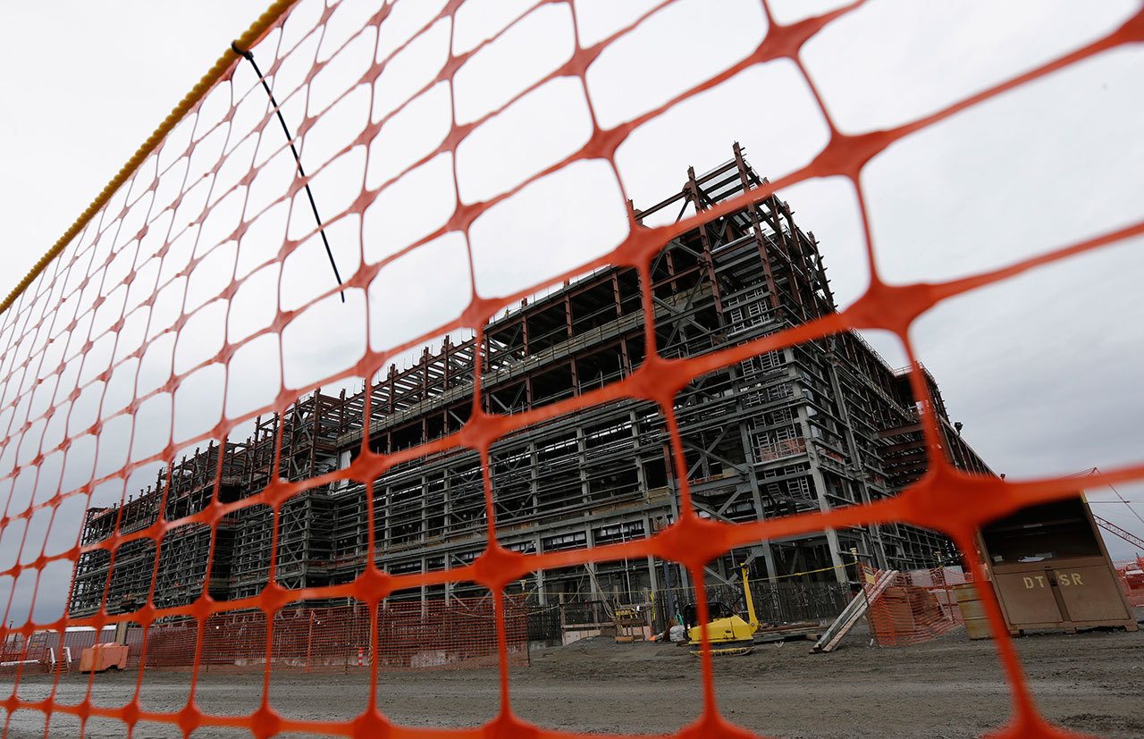 A waste treatment plant under construction is shown behind a plastic fence on the Hanford Nuclear Reservation near Richland in 2013. Federal prosecutors say Bechtel National Inc. and a subcontractor have agreed to pay $125 million to settle a lawsuit alleging subpar work in the construction of a nuclear waste treatment facility on the Hanford Nuclear Reservation. (Ted S. Warren/The Associated Press)