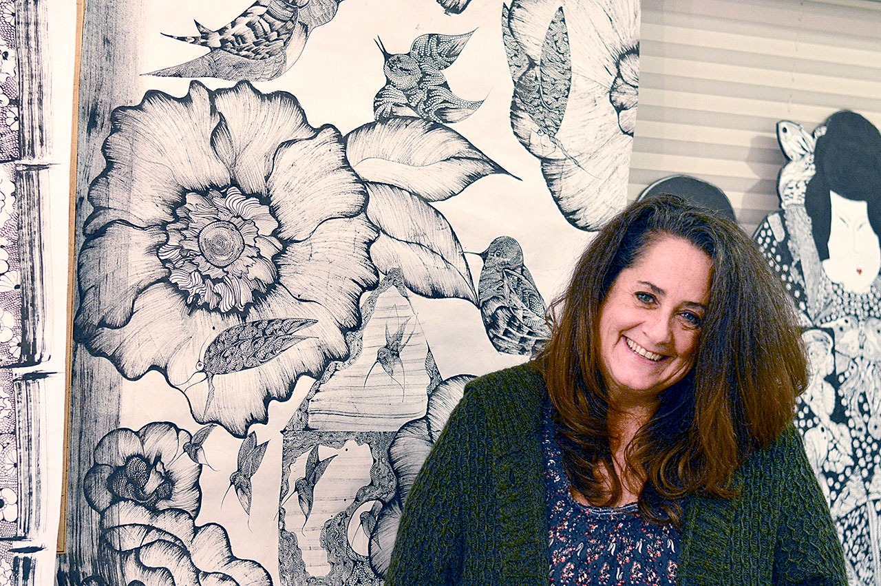 Erica McClain, a Sequim artist, stands before one of her creations. (Diane Urbani de la Paz/for Peninsula Daily News)