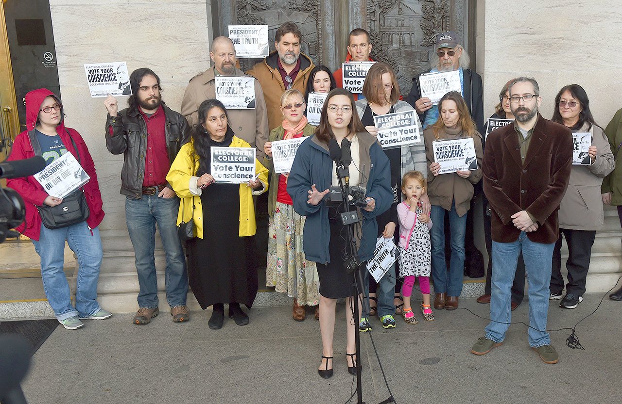 Washington state presidential elector Levi Guerra, center, joined by fellow elector P. Bret Chiafalo, right, announce that they’re asking members of the Electoral College to pick a Republican “consensus candidate” rather than Donald Trump during a news conference in front of the Legislative Building on Wednesday in Olympia. (Steve Bloom/The Olympian via AP)