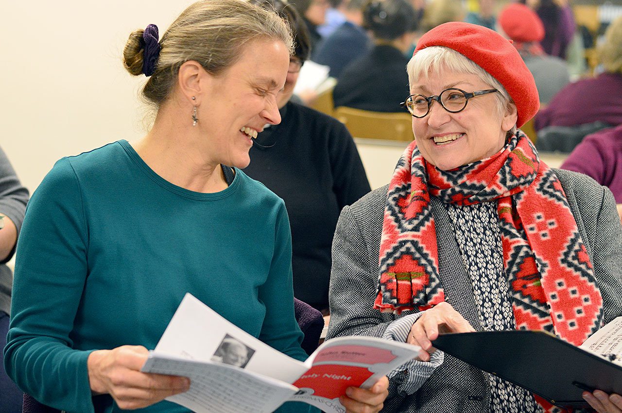 Altos Janis Burger, left, and Bonnie Christianson rehearse for the Port Angeles Symphony Chorus’ debut this Saturday. (Diane Urbani de la Paz/For Peninsula Daily News)