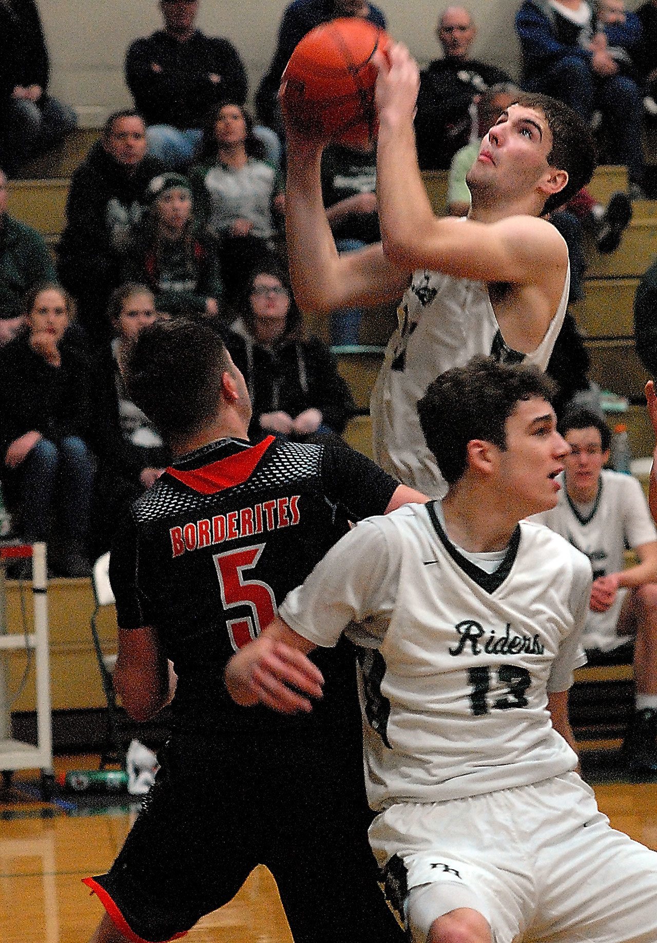 Keith Thorpe/Peninsula Daily News Port Angeles’ Grayson Peet, top, looks for the hoop as teammate Luke Angevine, front left, fends off the defense of Blaine;s Anthony Ball in the fourth quarter on Saturday at Port Angeles High School.