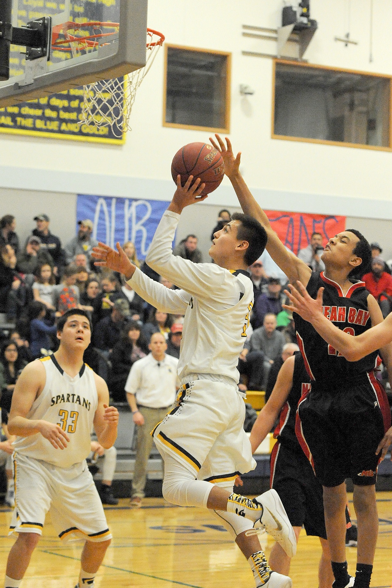 Lonnie Archibald/for Peninsula Daily News Forks’ Keishaun Ramsey shoots around the defense of Neah Bay’s Sean Bitegeko while the Spartans’ Austin Flores looks on.