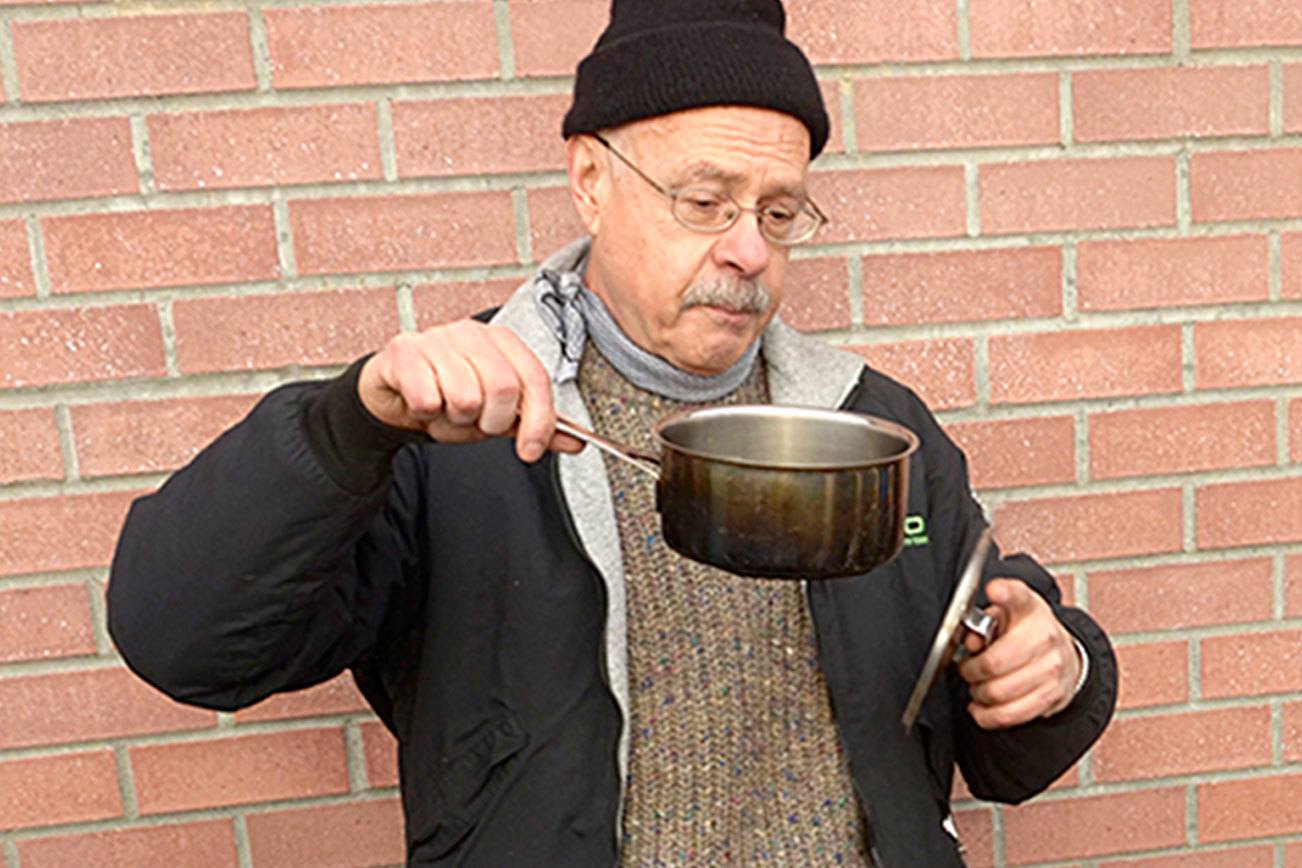 Devin Jensen and his mentor through the YMCA, Francesco Tortorici, hold a demonstration on stoves at Blue Heron Middle School. (Cydney McFarland/Peninsula Daily News)