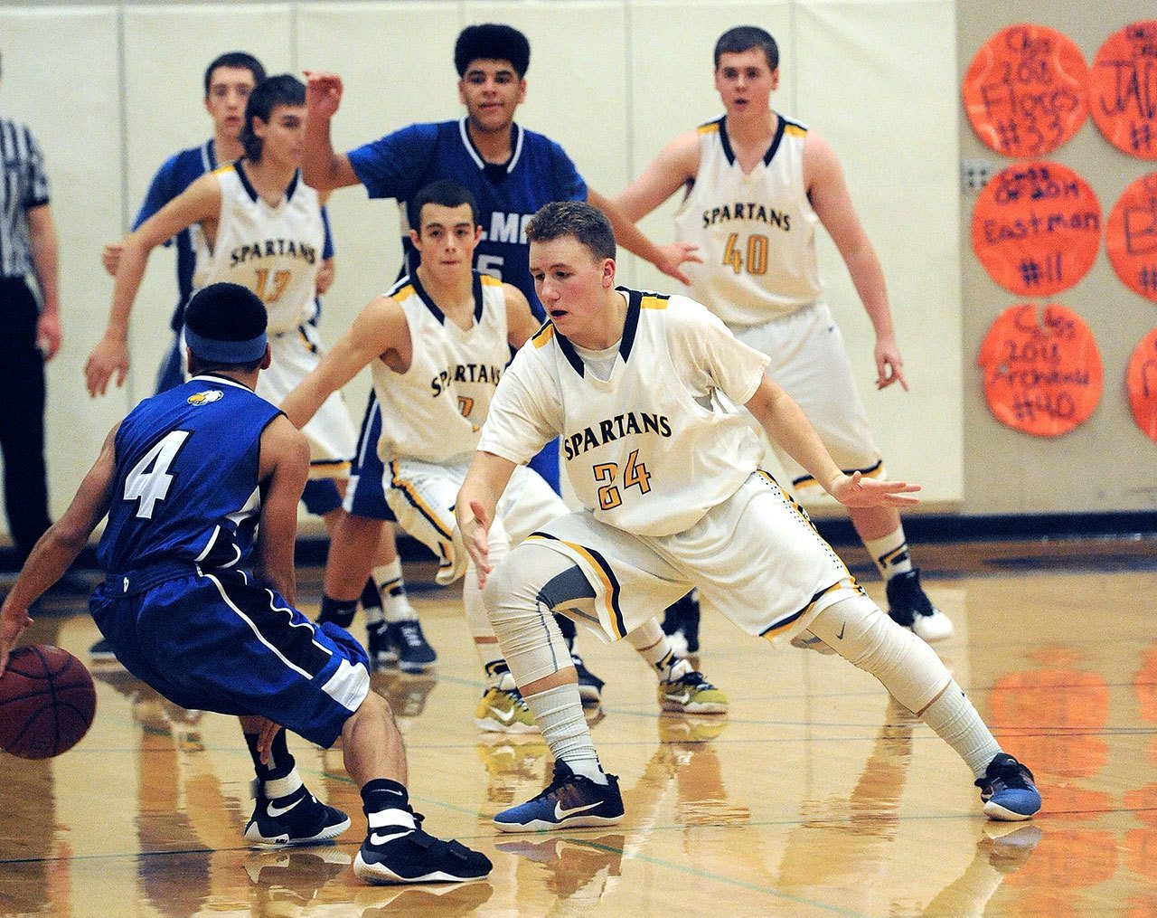 Lonnie Archibald/for Peninsula Daily News Elma’s Sohtye Tep (4) is denied a route to the basket by Forks defenders, from left, Jake Jacoby, Jeffery Schumack, Cort Prose and Scott Archibald. Also in the action for Elma is Marquess Peterson (5).