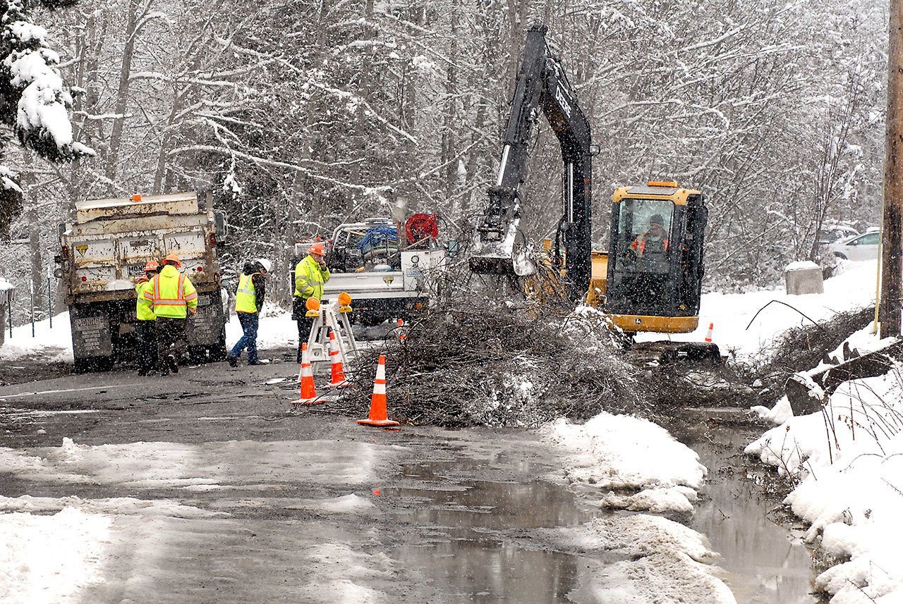 A Port Angeles Public Works Department crew excavates the site of a water main break in the 1200 block of East Craig Avenue that left about 120 homes without water and sent a cascade through the neighborhood early Wednesday morning. Dennis Edgington of the public works department said Wednesday that repairs would take most of the day. (Keith Thorpe/Peninsula Daily News)