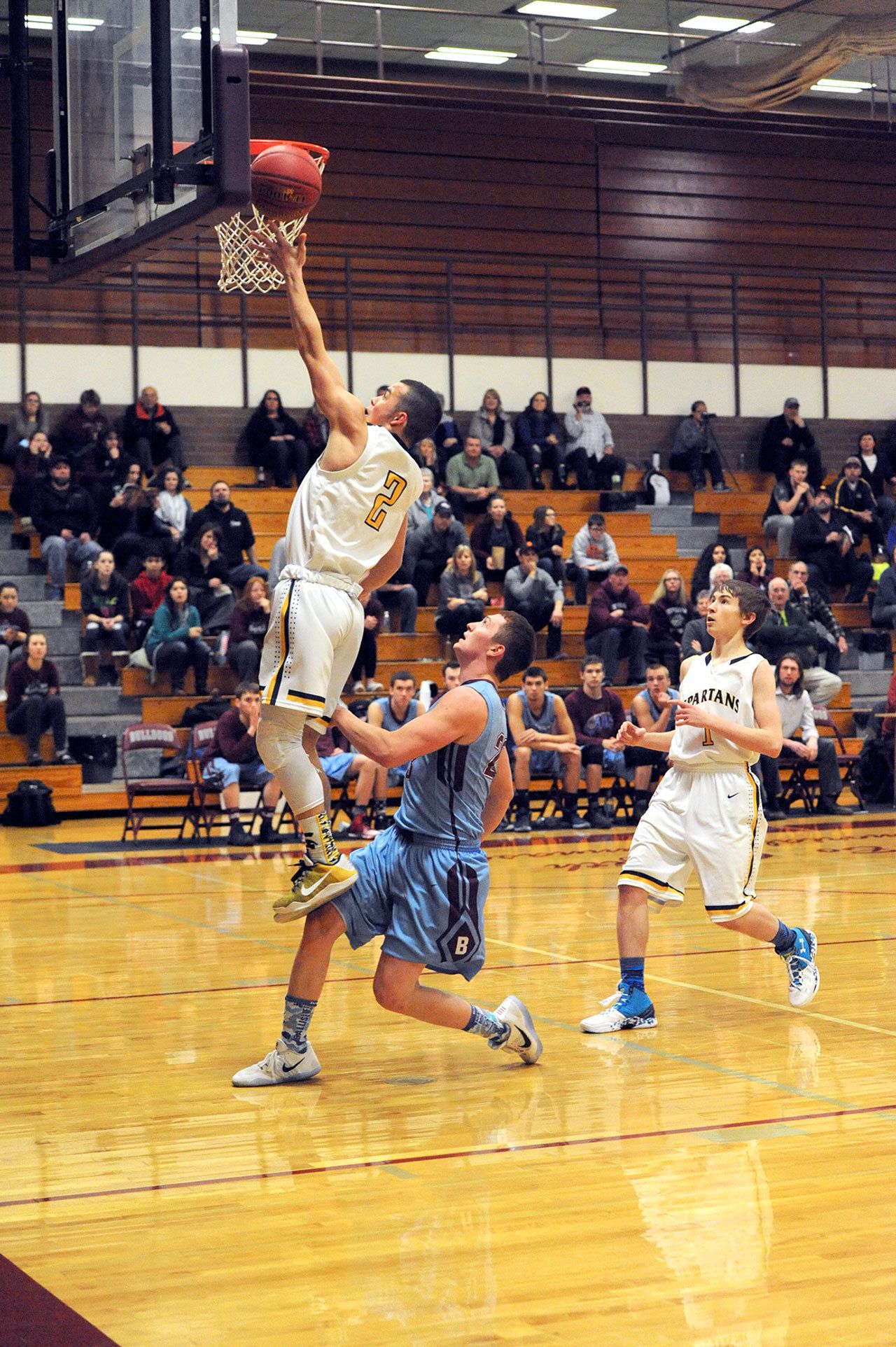 Lonnie Archibald/for Peninsula Daily News Forks’ Jeffery Schumack scores over Stevenson’s Alex Delarosa during the Spartans’ 68-56 Class 1A Southwest District 4 Tournament victory.