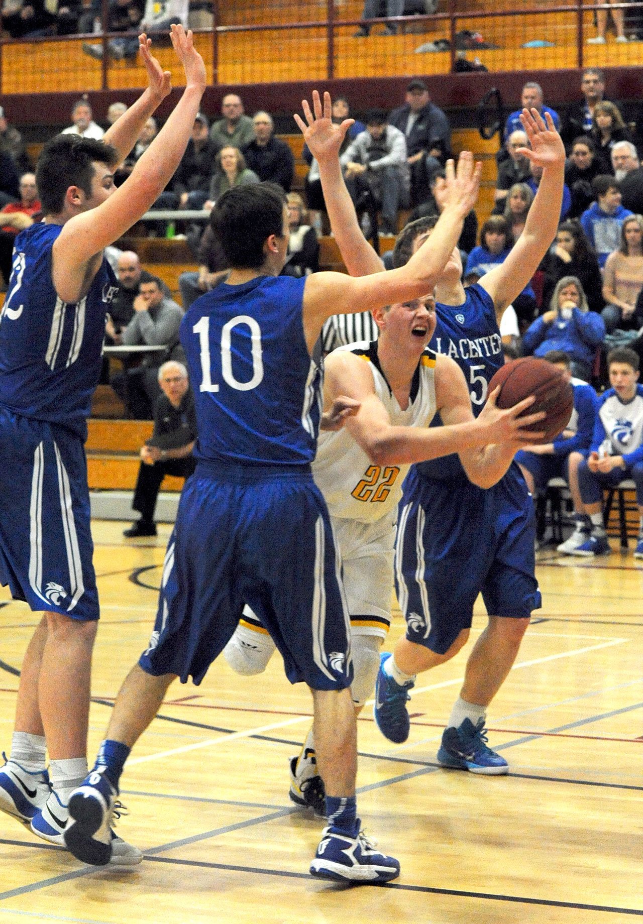 Lonnie Archibald/for Peninsula Daily News                                Forks’ Parker Browning is fouled as he drives the lane against La Center’s Joe Bork (10) and Jake Wise (5).