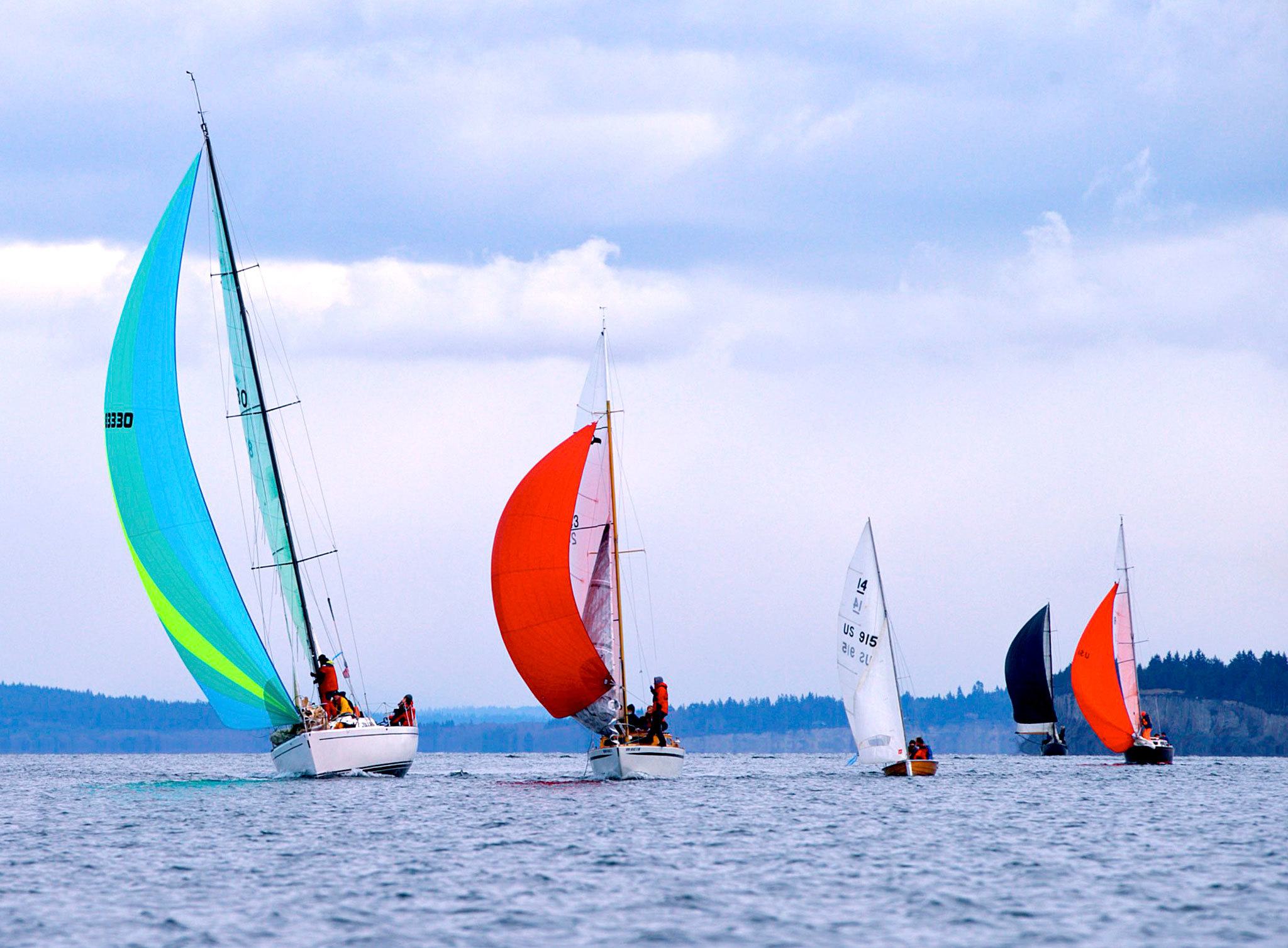 Steve Mullensky/for Peninsula Daily News A line of sailboats, on a downwind reach, compete in the 26th annual Shipwrights’ Regatta on Port Townsend Bay on Saturday.