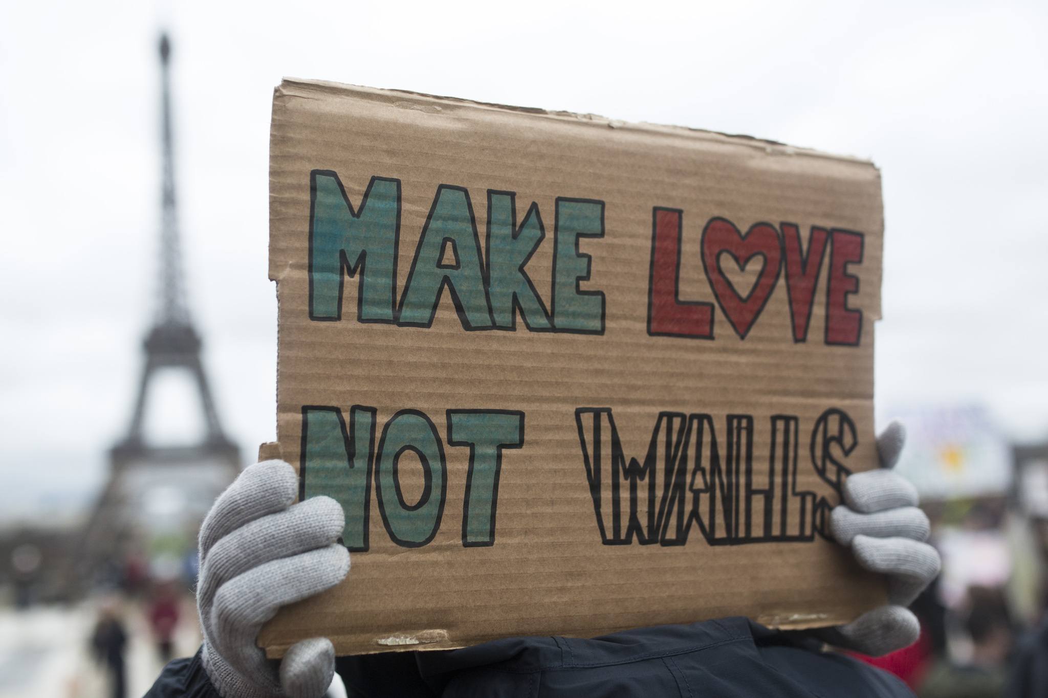 A woman holds a banner reading “Make love not walls” during a gathering Saturday at Trocadero Plaza next to the Eiffel Tower in Paris to protest U.S. President Donald Trump’s recent travel ban to the U.S. (Kamil Zihnioglu/The Associated Press)