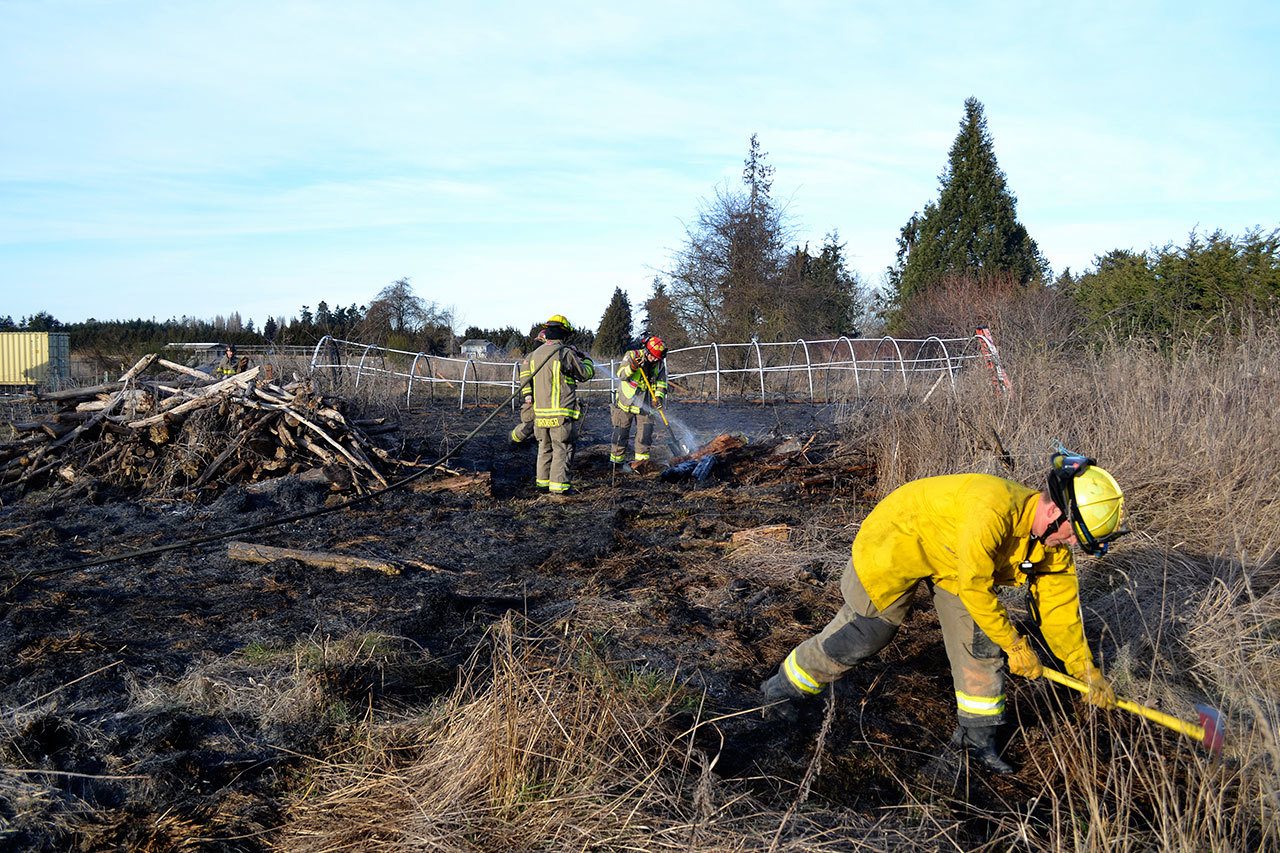 Clallam County Fire District No. 3 firefighters mop up a brush fire west of Sequim on Thursday. (Matthew Nash/Olympic Peninsula News Group)