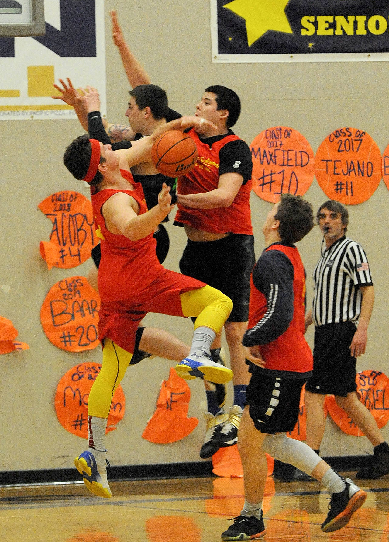 Lonnie Archibald/for Peninsula Daily News                                Dilley & Solomon Logging Co. players from left, Cole Baysinger, Austin Flores and Cort Prose compete with Ron’s Food Mart’s Drew Adams for ball control during the 20-team Nate Crippen Memorial Tournament at Forks High School. Ron’s defeated Dilley & Solomon 77-61. The two championship games, lower and upper brackets, are s