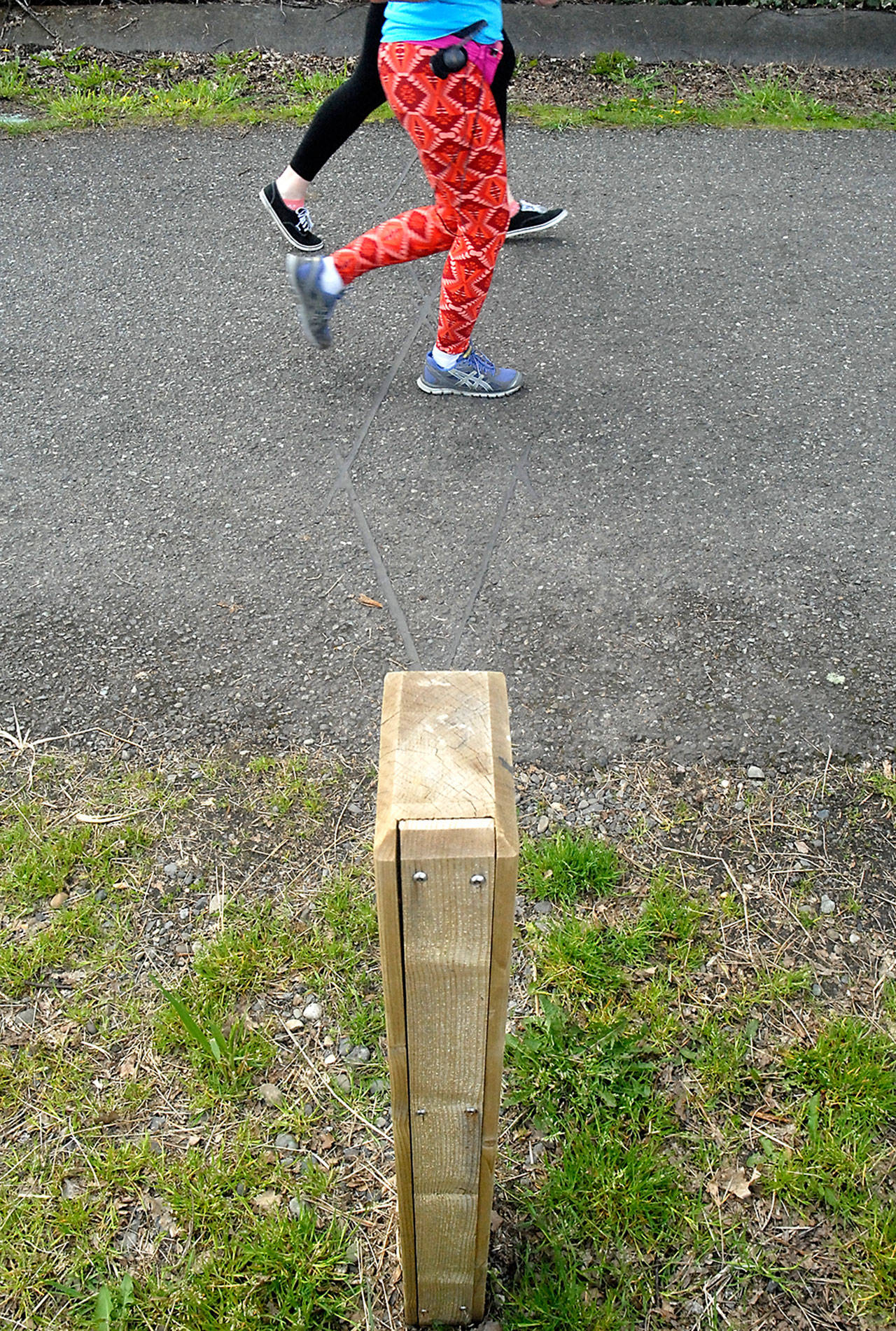 Joggers pass over a sensor imbedded in the pavement that tallies foot and bicycle traffic on the Waterfront Trail east of Port Angeles City Pier. (Keith Thorpe/Peninsula Daily News)