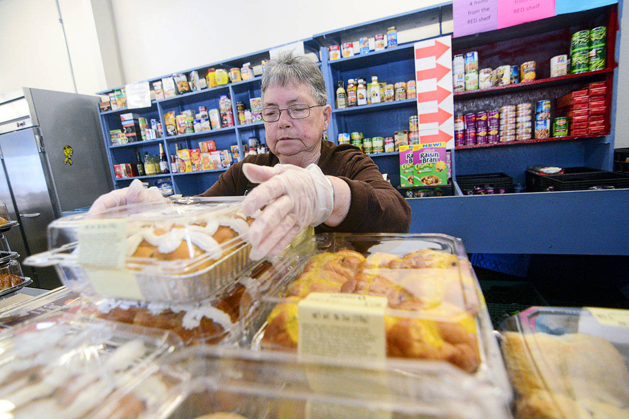Mary Patterson, who recently received the Governor’s Volunteer Service Award, stocks food at the Port Angeles Food Bank on Monday. (Jesse Major/Peninsula Daily News)