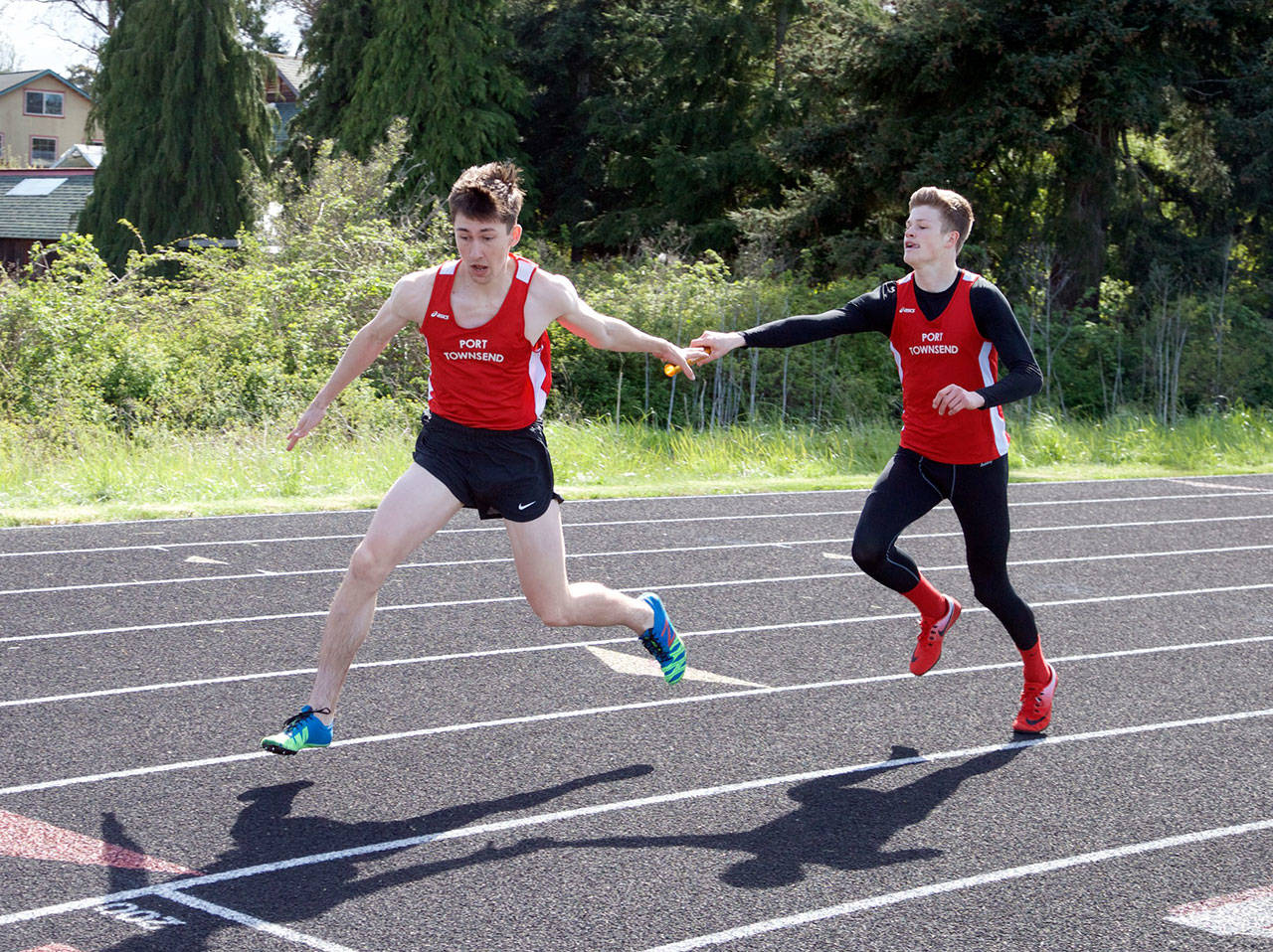 Steve Mullensky/for Peninsula Daily News Port Townsend’s Seren Dances takes the baton from teammate Berkley Hill and runs the anchor leg of the boys 4X200 relay race during a meet at Blue Heron Middle School on Friday. The team, consisting of Dances, Hill, Gerry Coker and Kyle Blankenship, went on to set an new school record in the race with at time of 1:33.49.