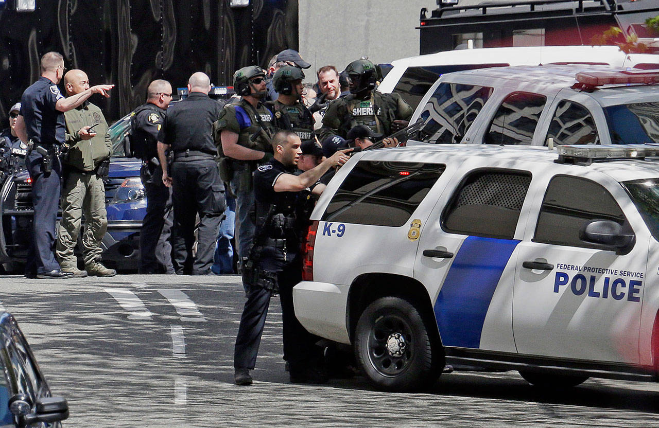 Police officers crowd a street adjacent to the scene of a shooting involving several police officers in downtown Seattle on Thursday. (Elaine Thompson/The Associated Press)