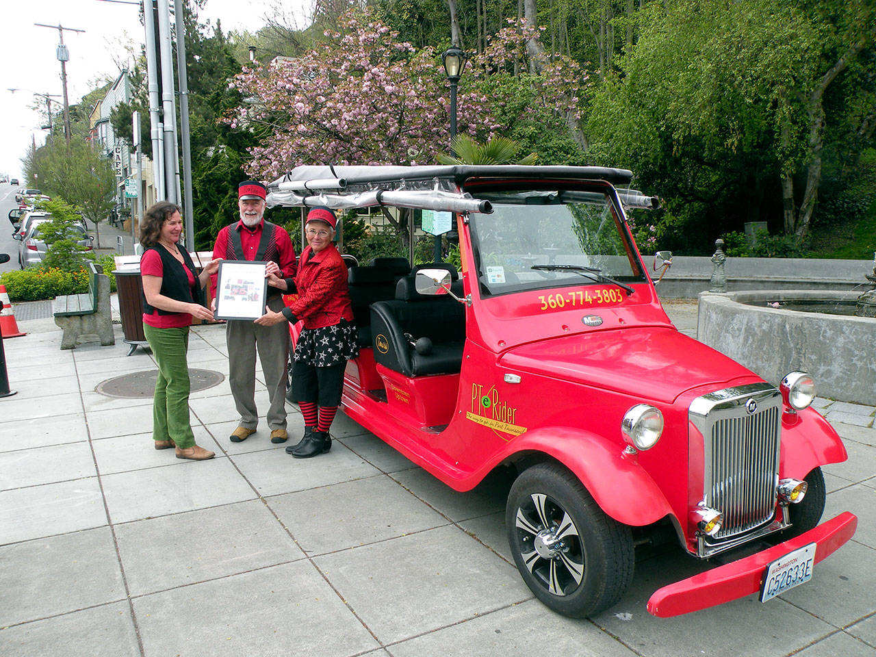 Port Townsend Main Street board member Connie Segal, left, delivers the “Sustainable Future” award to Myron Gauger and Kate Dwyer, owners of PT eRider. (Mari Mullen)