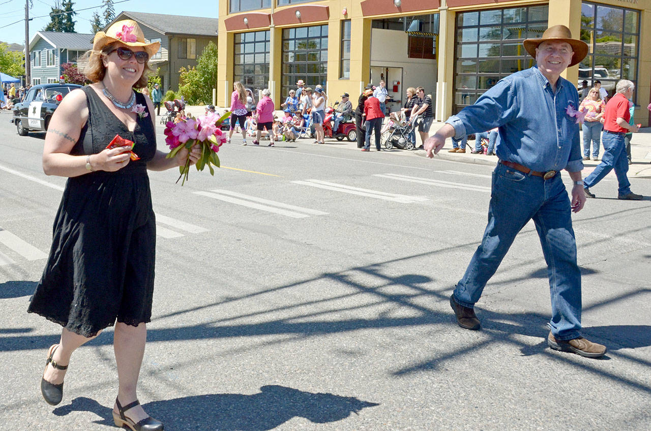 Jefferson County Commissioners Kate Dean and David Sullivan wave and hand out candy during the Rhody Festival Grand Parade in Port Townsend on Saturday. (Cydney McFarland/Peninsula Daily News)