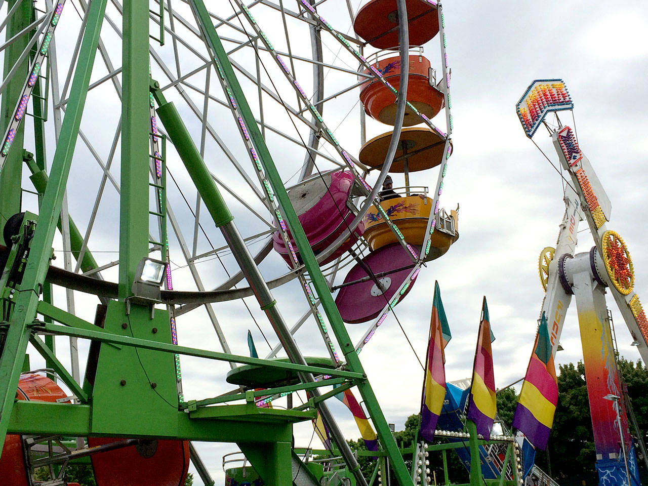 A gondola damaged in a May 18 mishap hangs from a Ferris wheel gondola shortly after three occupants fell during the Rhododendron Festival carnival in Port Townsend. (Port Townsend Police Department)