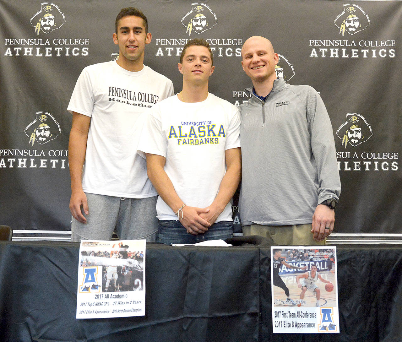 Peninsula College Athletics Peninsula College men’s basketball players, from left, Alex Baham and Jalon McCullough are pictured with Pirates head coach Mitch Freeman after signing letters of intent to continue their college careers with the University of Alaska-Fairbanks. Baham is from Wasilla, Alaska and McCullough is from Fairbanks.