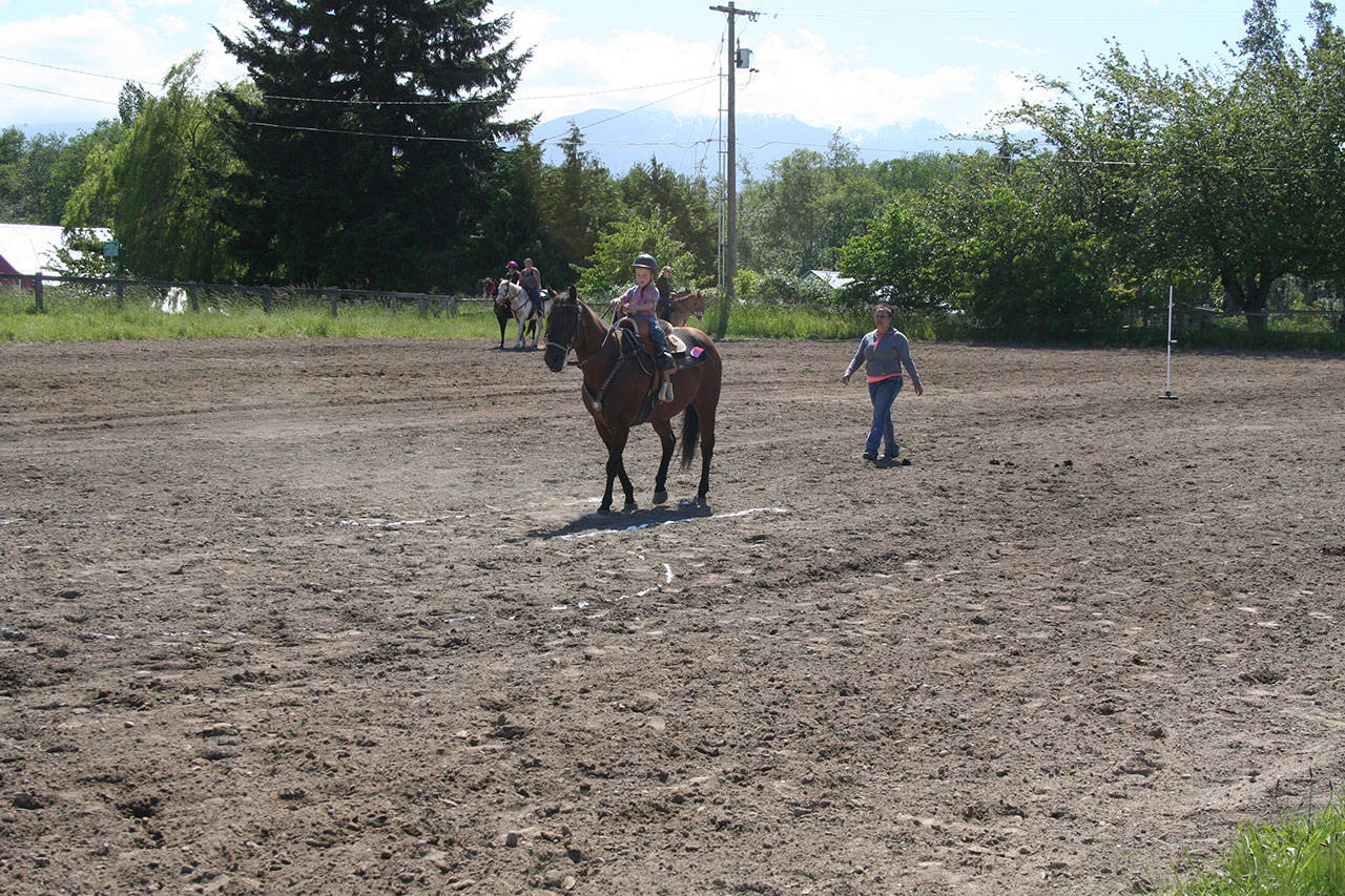 Under mom Tanya Hull’s guidance, 4-year-old Levi Hull directs the horse’s hooves inside the white lines for a clean run during the keyhole event at last Sunday’s Patterned Speed Horse Association show at Quarter Moon Race in Carlsborg. (Karen Griffiths/for Peninsula Daily News)