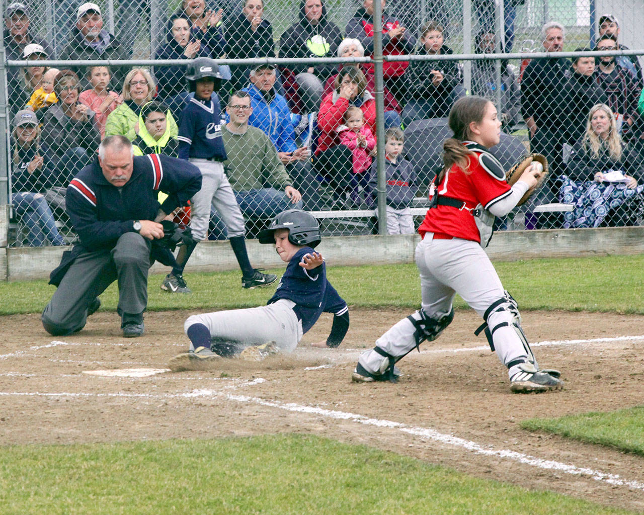Lions’ Rylan Politika slides safely into home plate as Local 155 catcher Myles Bowechop catches the ball during Lions’ 5-4 Cal Ripken Majors City Championship victory. Dave Logan/for Peninsula Daily News