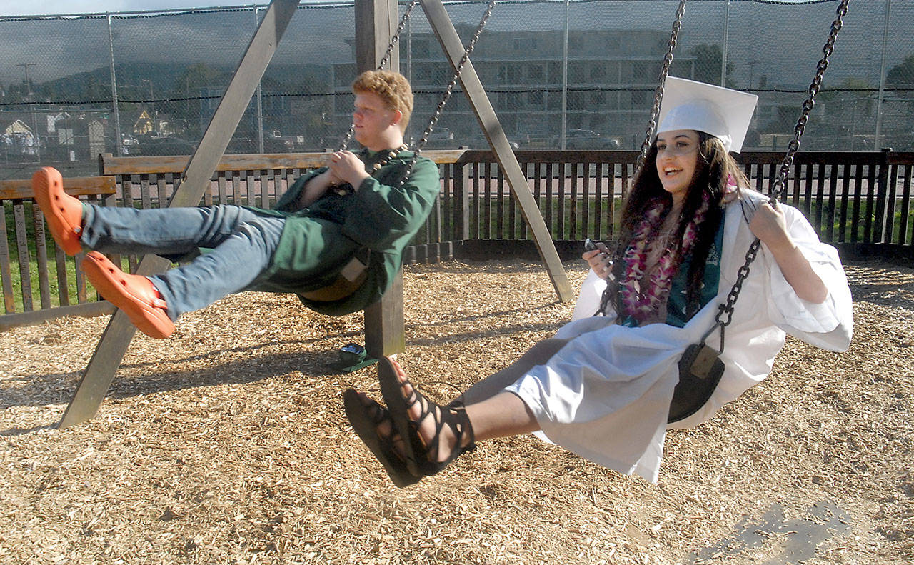 Port Angeles High School seniors Gabe Wegener, left, and Mia DelGuzzi-Flores enjoy time on the swingset at the Dream Playground at Erickson Playfield prior to Friday night’s commencement ceremony at nearby Civic Field. A total of 237 students were scheduled to graduate as part of the high school’s class of 2017. (Keith Thorpe/Peninsula Daily News)