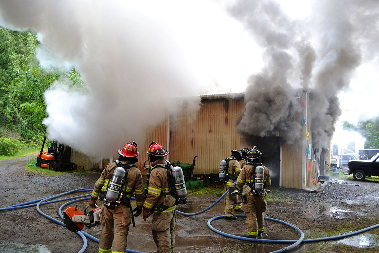 East Jefferson Fire-Rescue firefighters combat a blaze at Custom Auto Craft and Sales, located on Cape George Road, on Saturday evening. (Bill Beezley/East Jefferson Fire-Rescue)