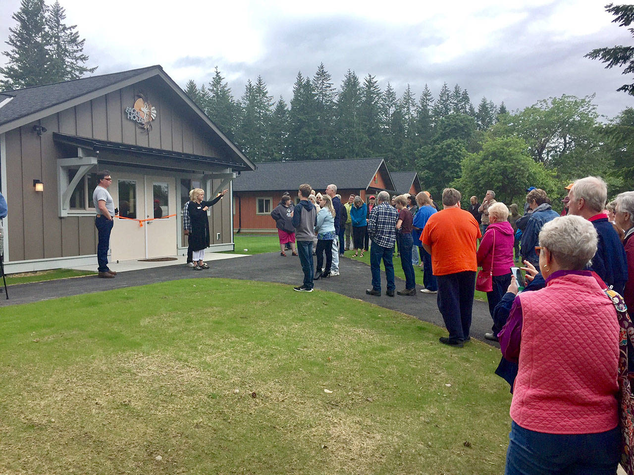 Rod Barrow, left, project manager for G. Little Construction, and Claudia Edmondson, executive director, welcome supporters to new housing at Camp Beausite on Saturday. (Cheryl Smith/Camp Beausite NW)