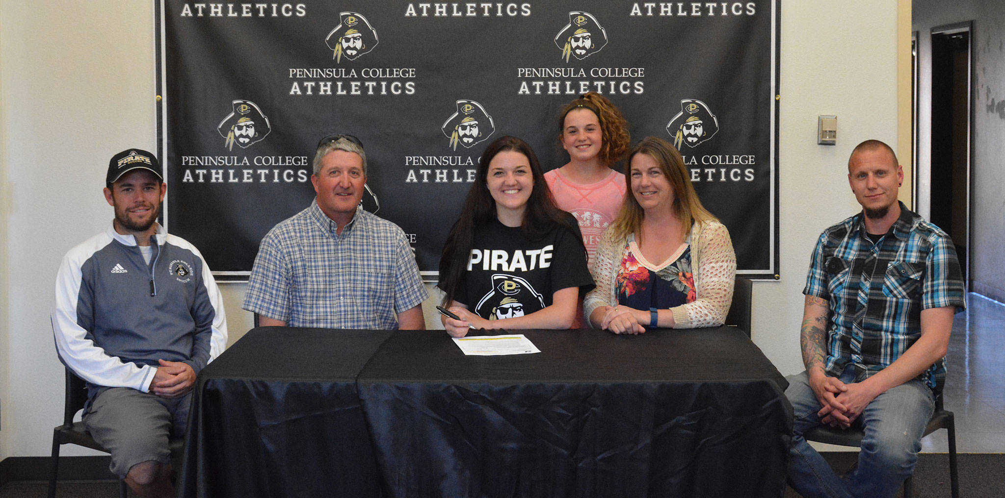 Peninsula College Athletics                                Sequim’s Erin Vig (center) in May signs a letter of intent to play at Peninsula College this fall. Joining her are, from left, PC head coach Kanyon Anderson, dad Craig, sister Lainey, mom Julie and Sequim High head coach Derek Vandervelde.