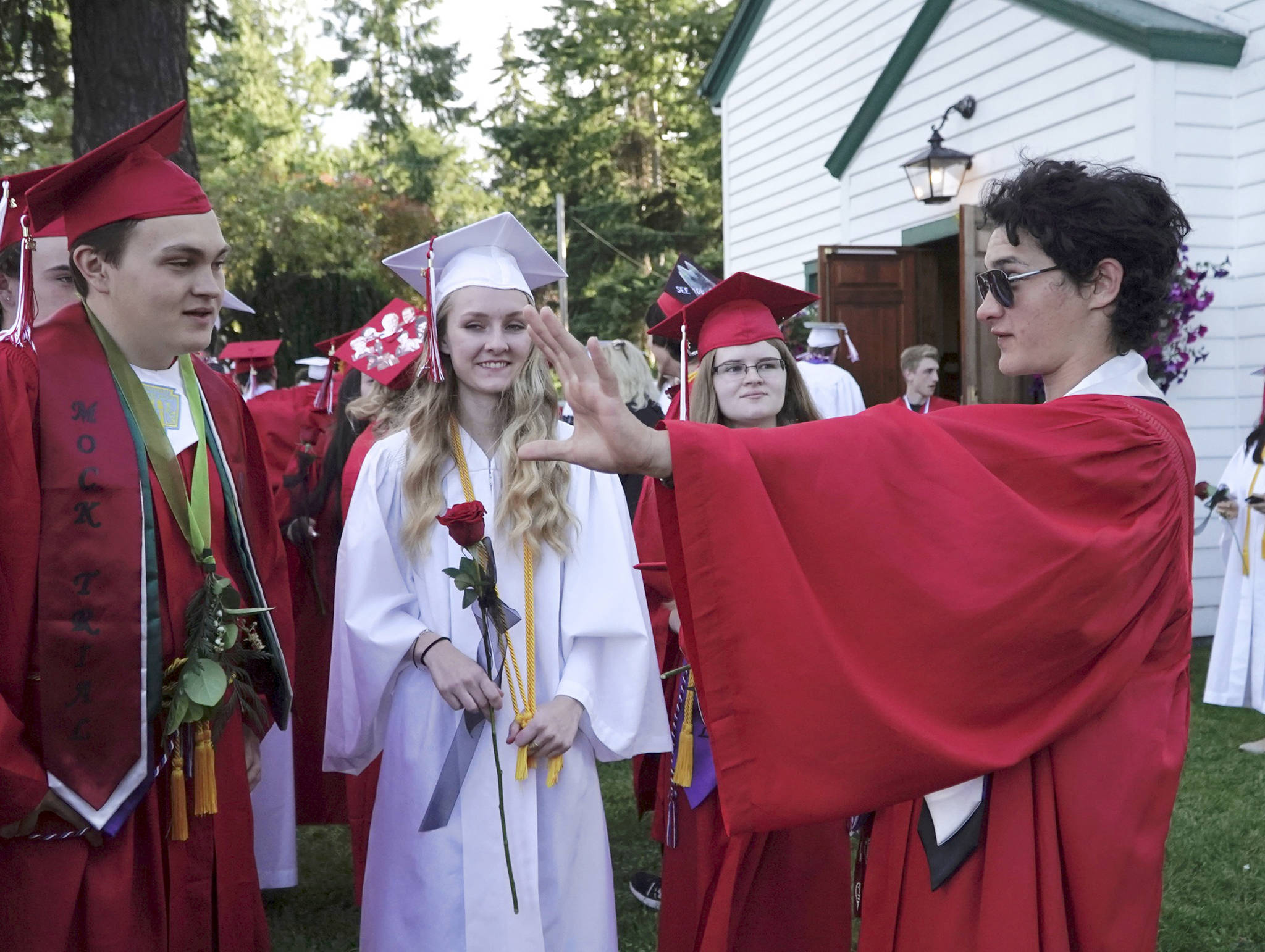 Henry Veitenhans, right, regales fellow graduating seniors Gannon Short, Rosemary D’Andrea and Helena Stafford, from left, with tales of his harrowing adventure while crossing the Strait of Juan de Fuca in gale-force winds during Thursday’s Race to Alaska. The 17-year-old senior entered the race as his senior project. He arrived in Victoria on Friday morning, after having put in for shelter about a mile from Victoria Harbor, then made his way back to Port Townsend to attend Friday’s graduation. (Steve Mullensky/for Peninsula Daily News)
