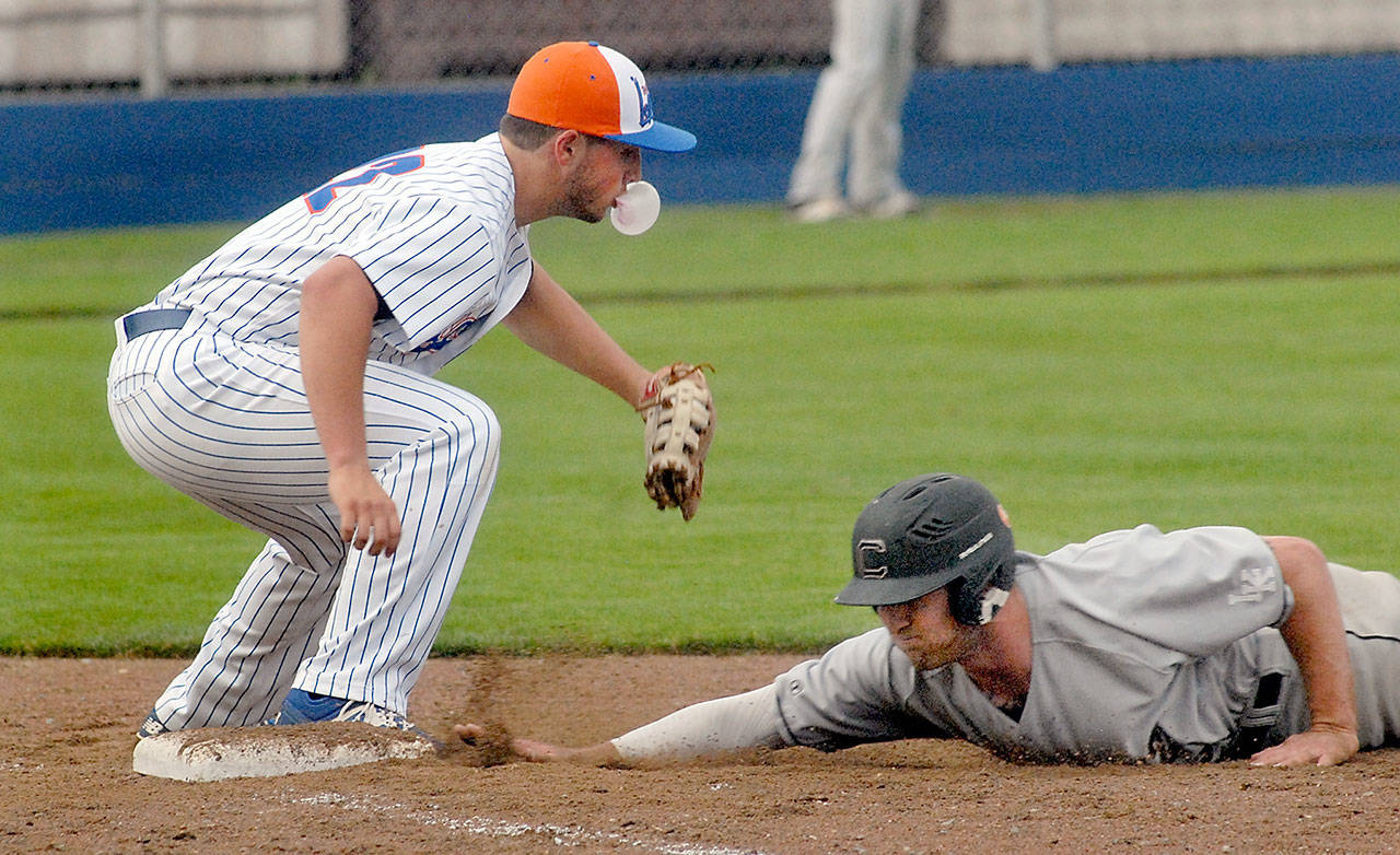 Lefties first baseman Michael Ciancio blows a bubble with his chewing gum while trying to catch Cowlitz’ Austin Ingraham off the bag during Port Angeles’ 6-1 win. Keith Thorpe/Peninsula Daily News