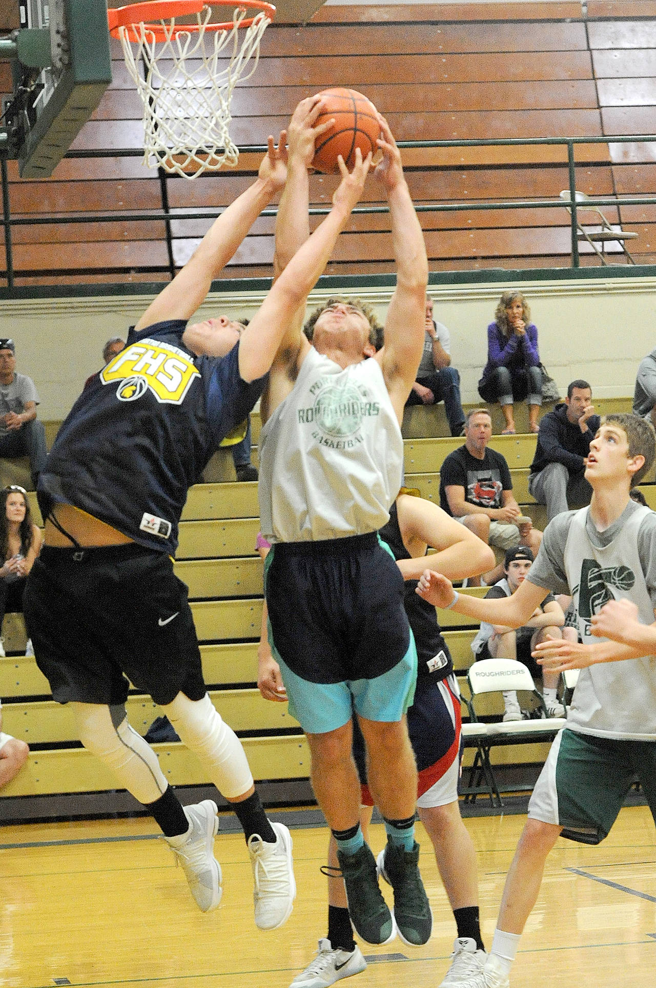 Lonnie Archibald/for Peninsula Daily News Forks Austin Flores, left, tries to wrestle the ball away from Port Angeles’s Anton Kathol during the Roughrider Summer Classic on Sunday in Port Angeles. Port Angeles topped Forks 53-37.