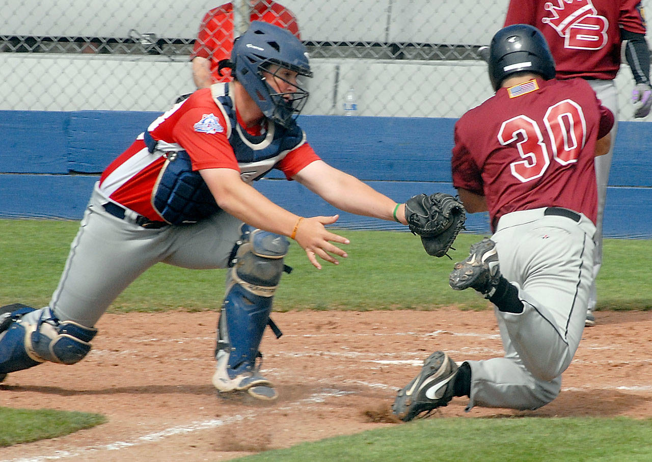 Keith Thorpe/Peninsula Daily News Wilder catcher Brody Merritt attempts to tag Mikio Habu of the Beyond Borders team in the third inning on Saturday morning at Port Angeles Civic Field.